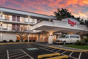 A Red Roof Inn with a two-story building, a parking lot, and a van parked in front. - Red Roof Inn Baltimore South - Glen Burnie (Glen Burnie)