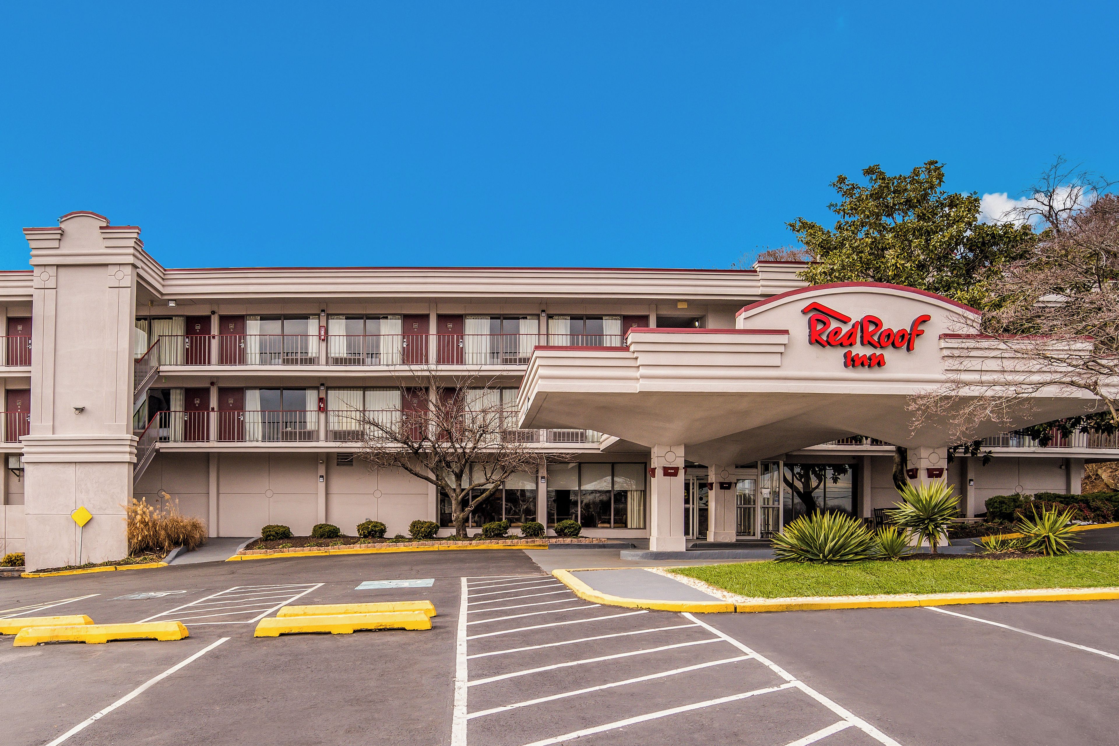 A Red Roof Inn with a parking lot and a covered entrance.