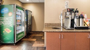 Un coin cuisine équipé d’une machine à café, d’un distributeur de boissons et d’un réfrigérateur rempli de boissons.