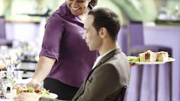 Una persona sirve comida a otra persona en una mesa de restaurante.