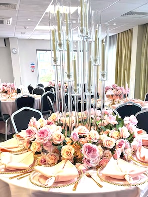 A banquet table with pink roses, clear glass candle holders, and gold detailing. - Novotel Wolverhampton (Wolverhampton)