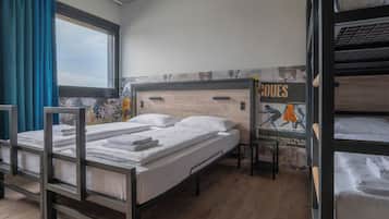 Un dormitorio con literas, una ventana con cortinas y un cartel en la pared.