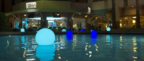 Un hôtel doté d’un espace piscine agrémenté de décorations sphériques bleues et blanches illuminées.