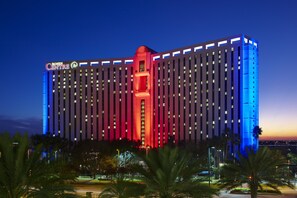 A large hotel with a prominent red and blue facade, multiple floors, and a central tower.