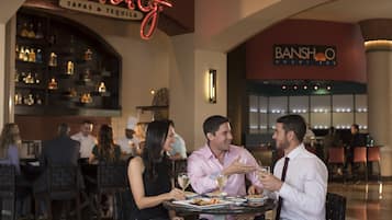 A couple dining at a restaurant with a neon sign above them.