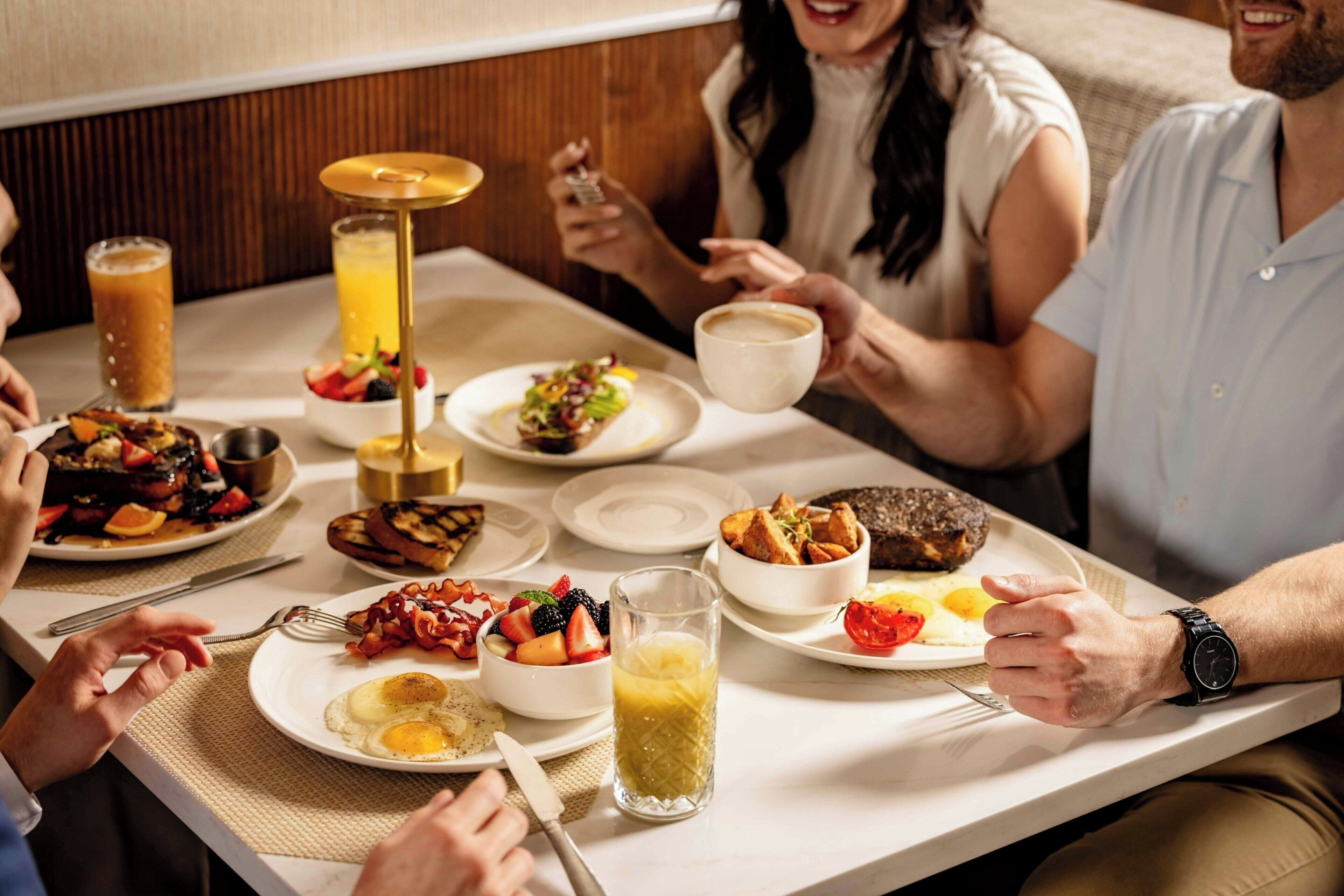 A dining table with breakfast items, including eggs, toast, and fruit.