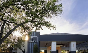 A modern hotel entrance with a sign reading 'HOTEL DAX.' - Hotel Dax (Addison)