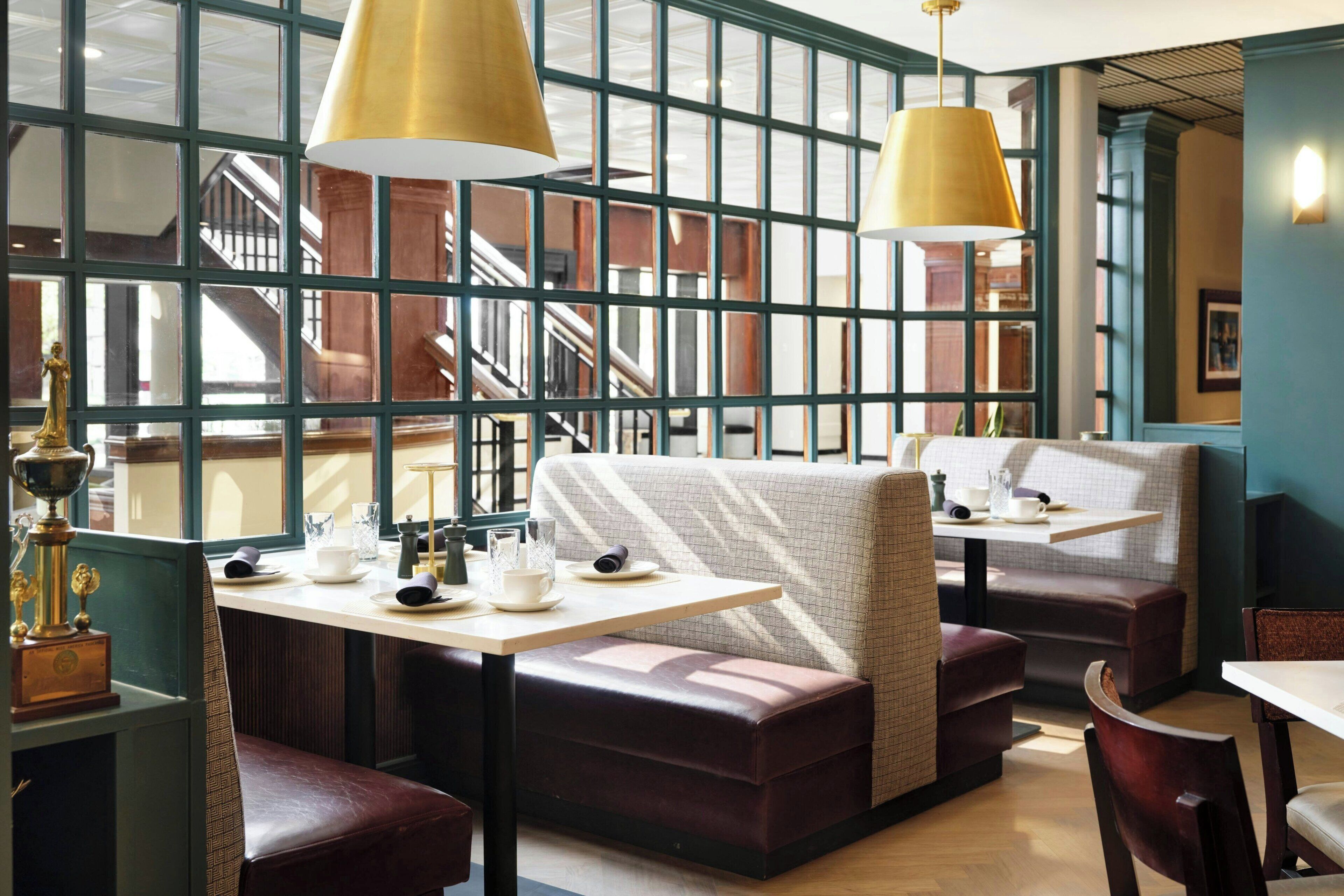A restaurant with booth seating, pendant lighting, and a view of the interior.