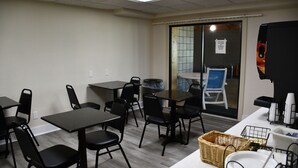Une pièce comprenant plusieurs tables et chaises, une poubelle, un panier et un distributeur automatique.