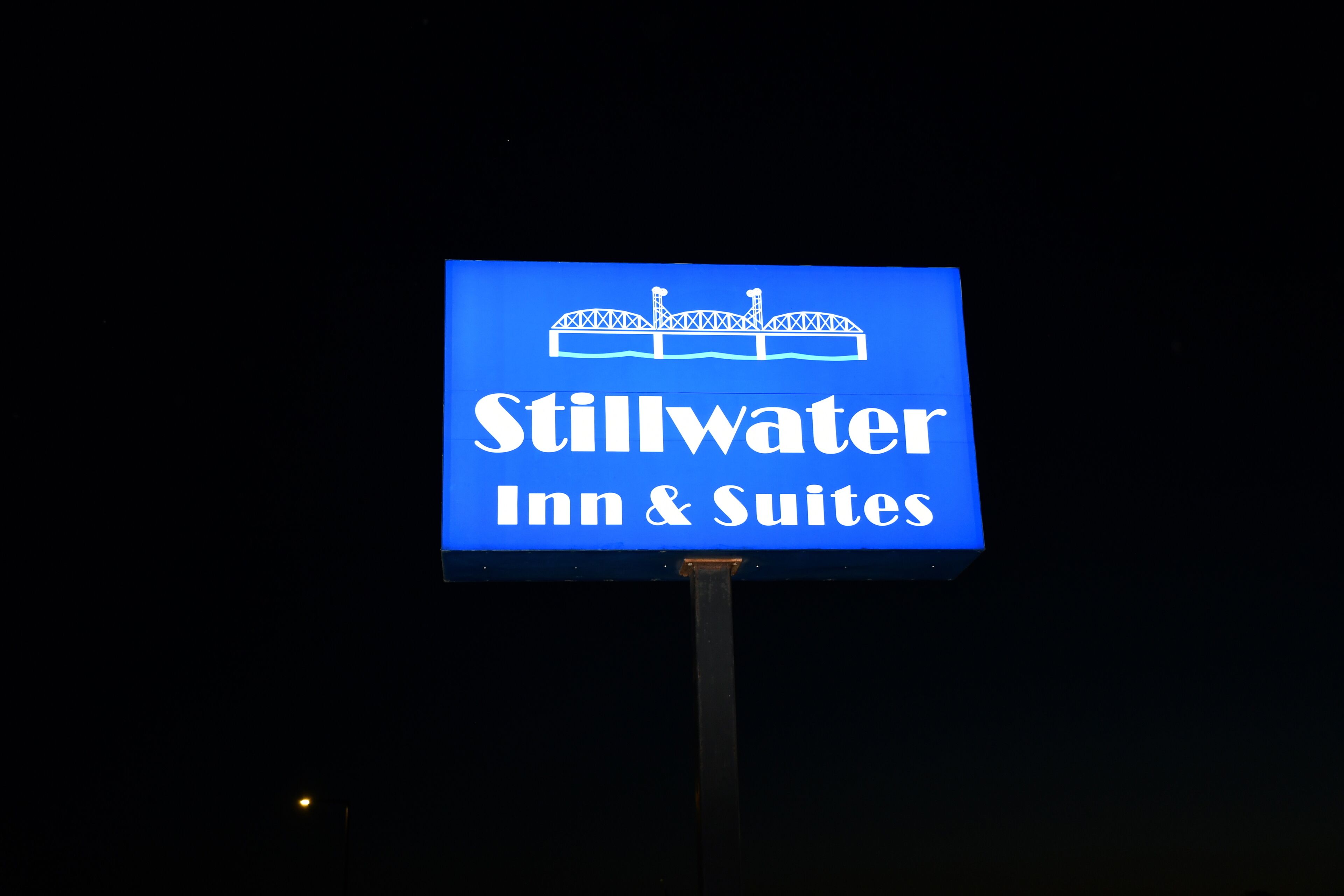 A sign for Stillwater Inn & Suites with a bridge illustration.