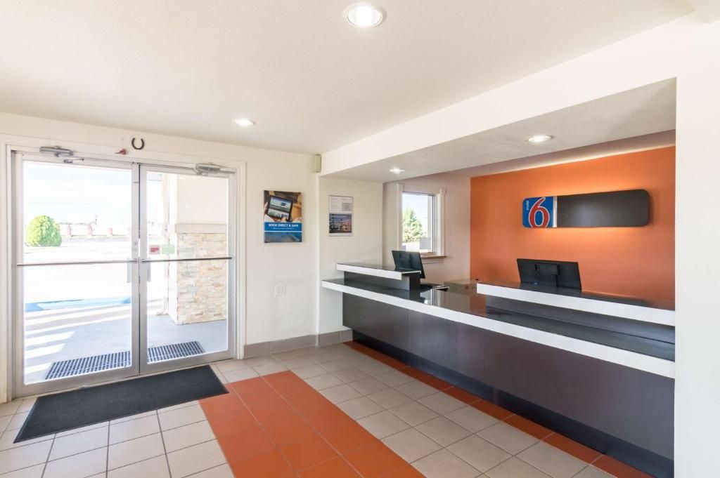 A reception area with a glass door entrance, a reception desk, and a wall-mounted sign.