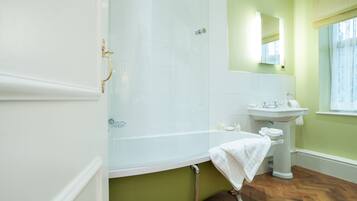 A bathroom with a bathtub, a sink, and a mirror.