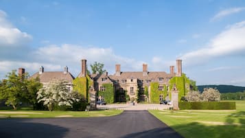 Stately building with a traditional facade, surrounded by well-manicured lawns and mature trees.