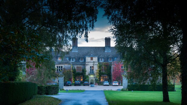 A large, historic building with a symmetrical facade, multiple chimneys, and a central entrance. - Llangoed Hall (Brecon)