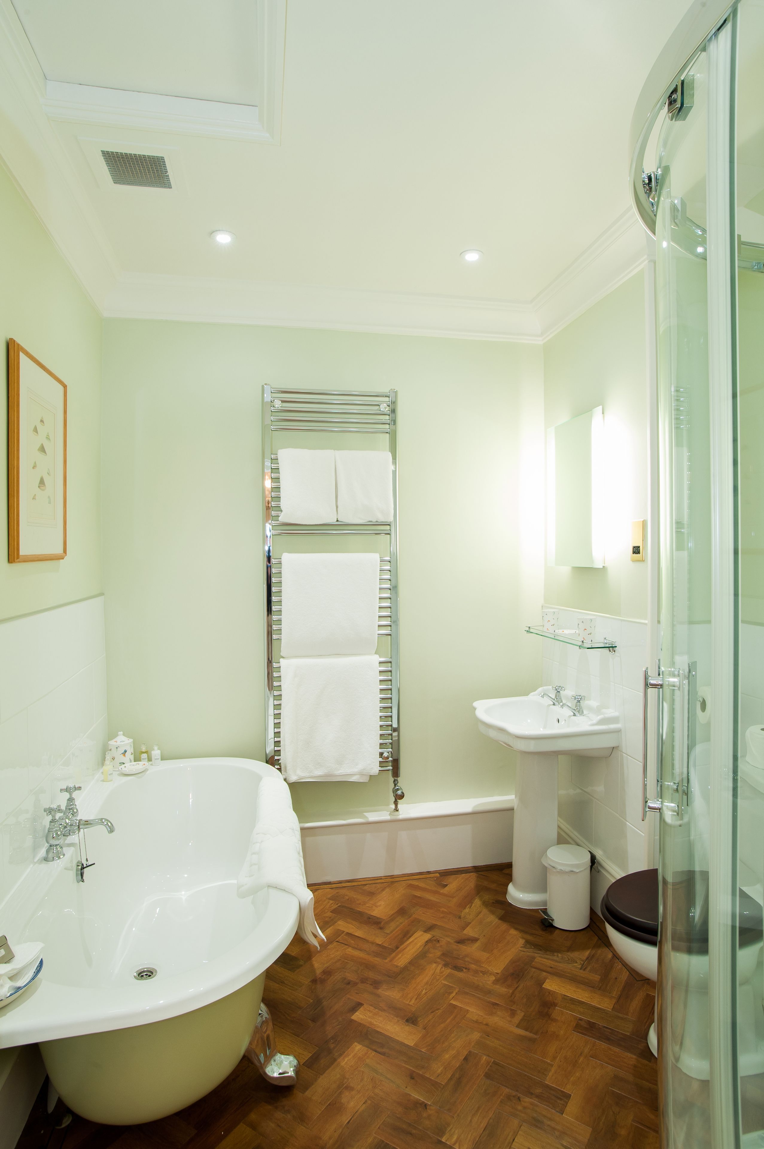 A bathroom with a freestanding bathtub, a sink, and a glass-enclosed shower.