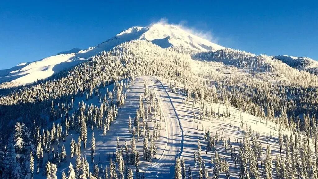 Una montaña nevada con una pista de esquí.