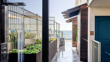 A narrow pathway leading to a balcony with a view of the sea.