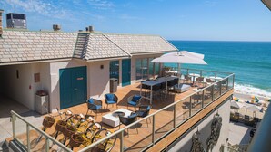 A seaside property with a balcony overlooking the ocean, featuring outdoor seating and a bicycle. - Beach Terrace (Carlsbad)