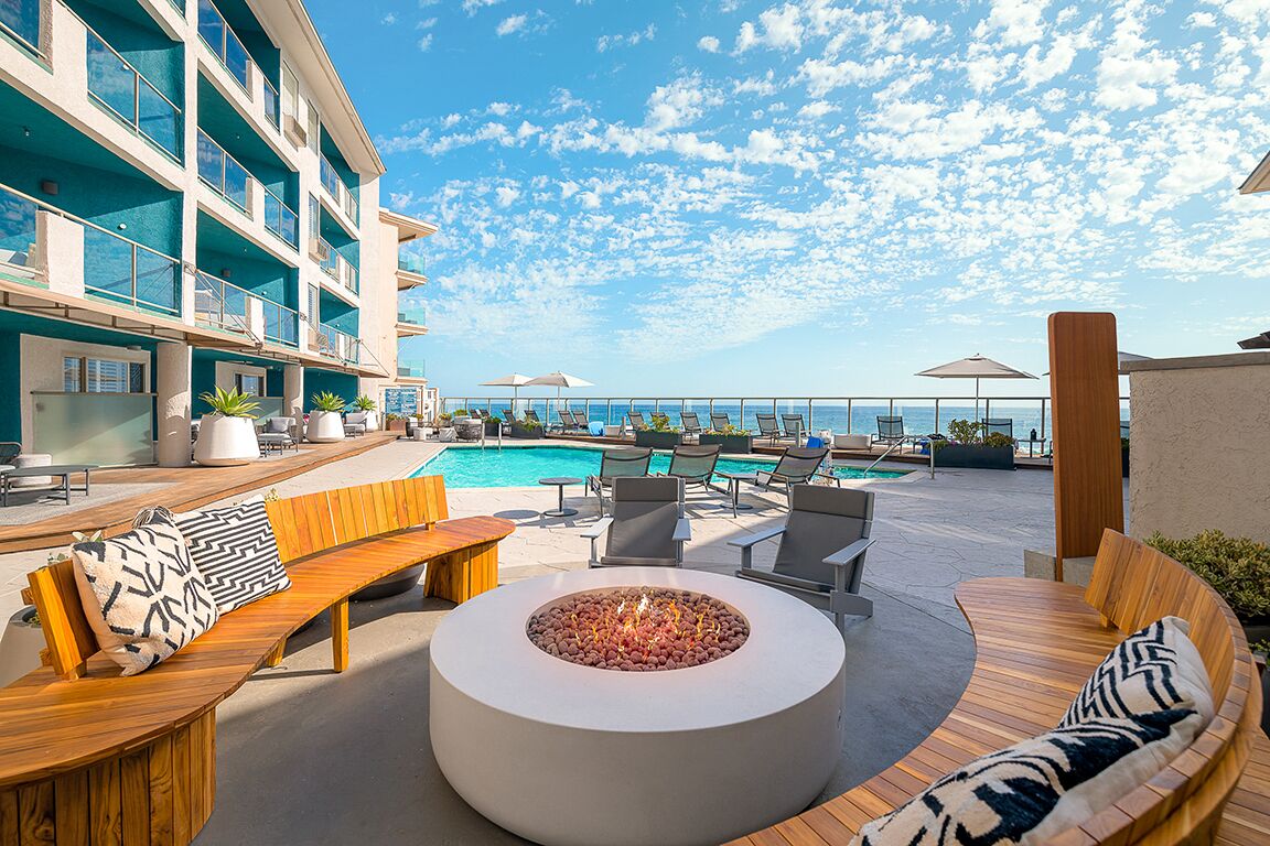 Una piscina al aire libre, sombrillas, sillones reclinables de piscina