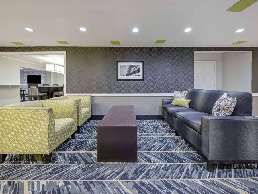 Un lobby moderno con un sofá, sillones y una mesa de centro.