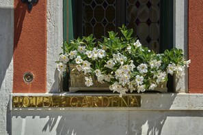 A hotel sign with a window display of white flowers. - Gardena Hotel (Venice)
