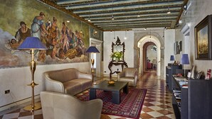 Un vestíbulo amplio con suelo de cuadros, sofás de cuero, una mesa de centro y un gran mural en la pared.