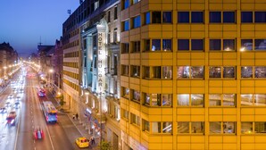 Un hôtel à plusieurs étages, doté d’une façade classique, et un immeuble moderne jaune attenant.
