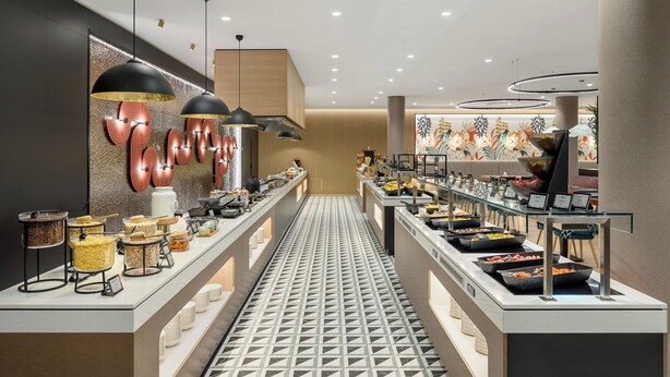 Un buffet proposant une variété de plats, un sol à motifs et un éclairage moderne.