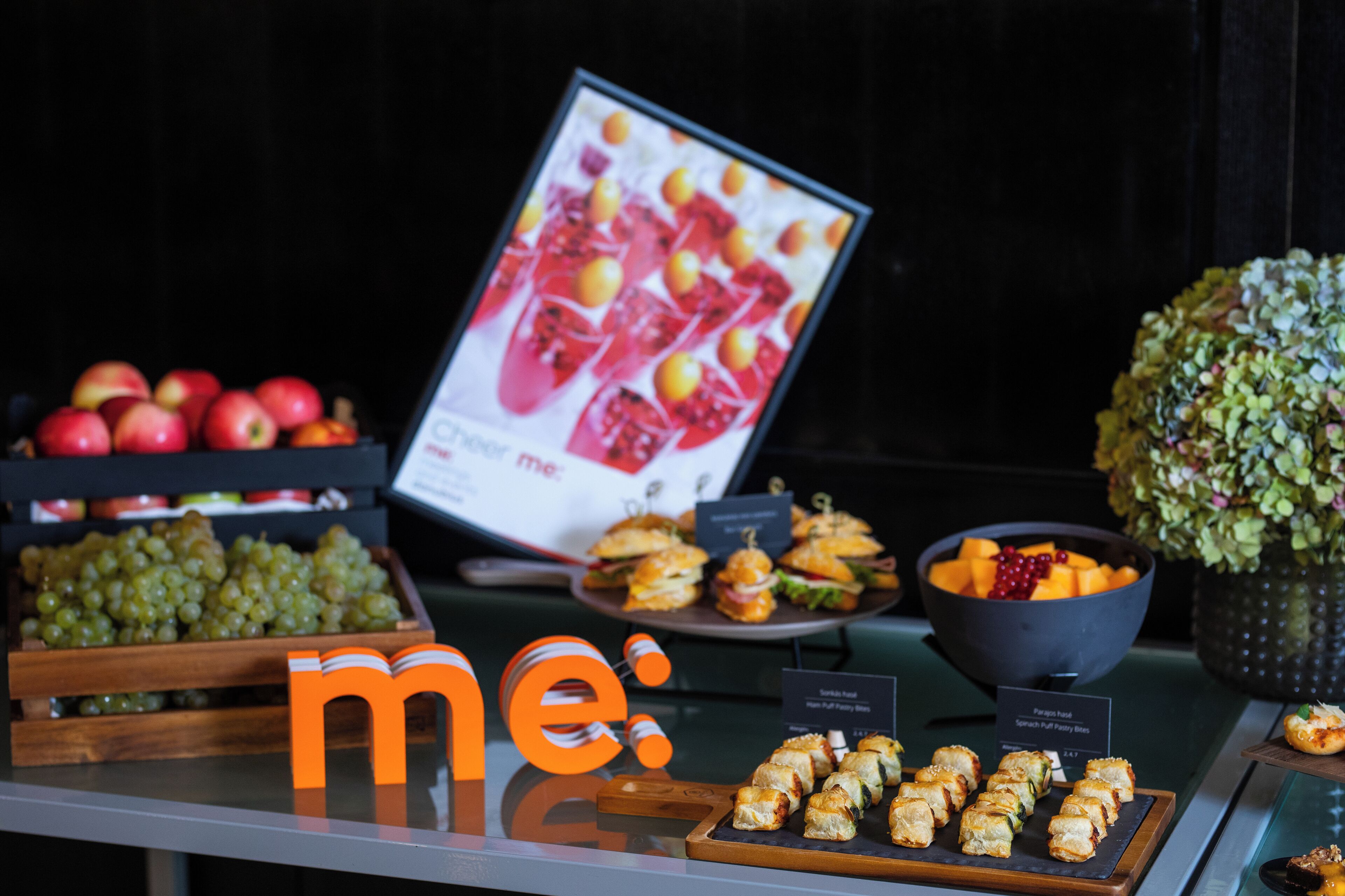 A buffet with various food items including fruits, sandwiches, and appetizers.