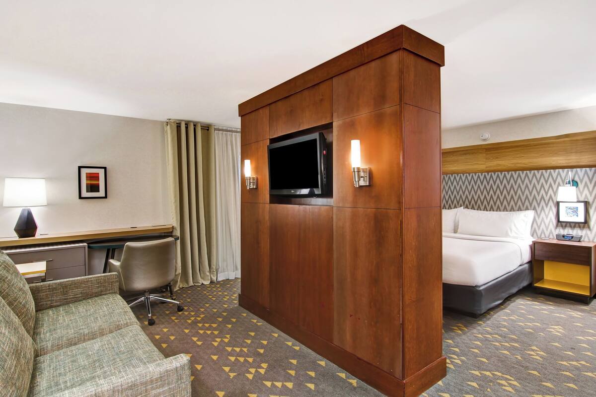 Une chambre d’hôtel équipée d’un lit, d’un bureau, d’une télévision et d’une chaise.