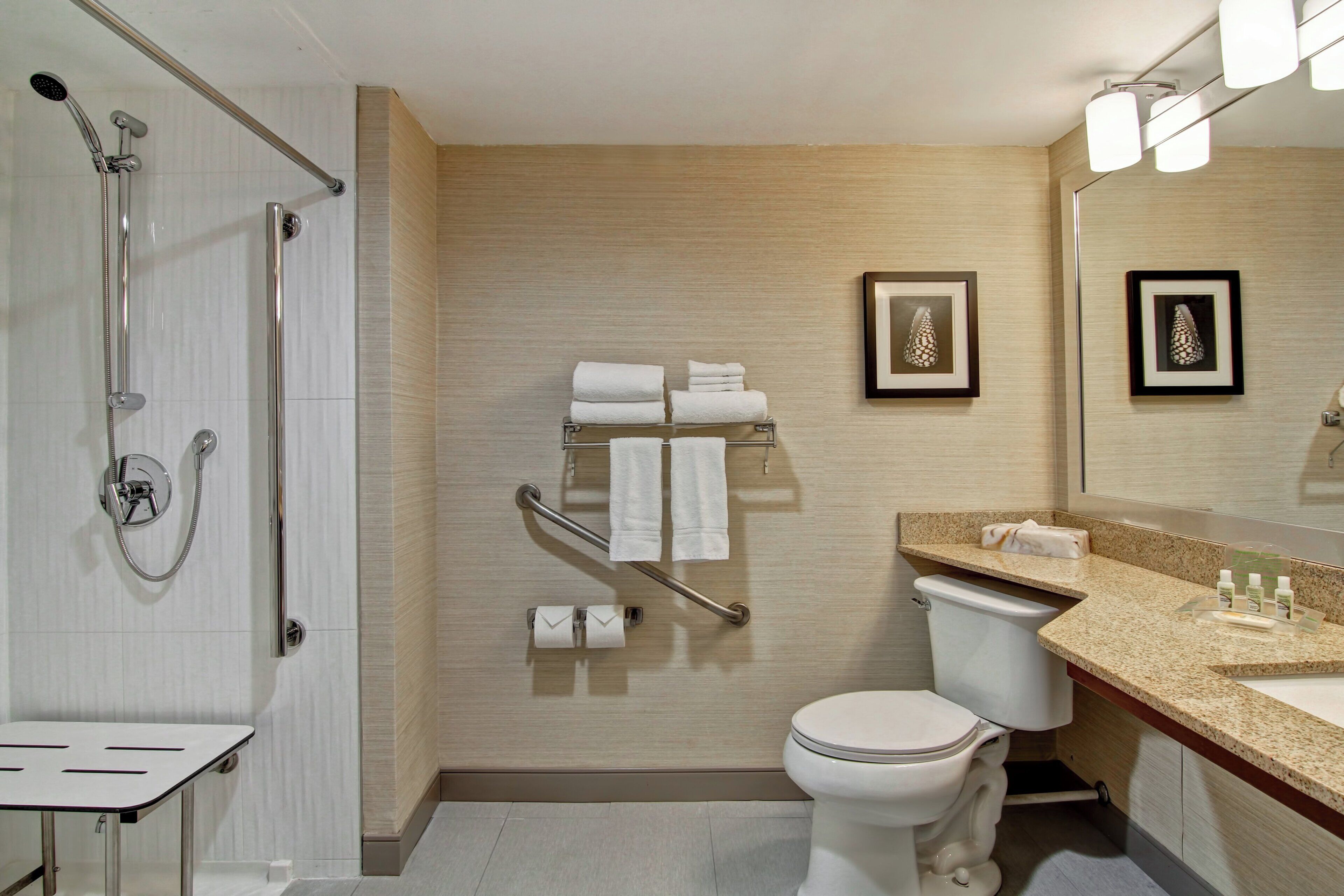 A modern bathroom with a shower, toilet, and vanity.