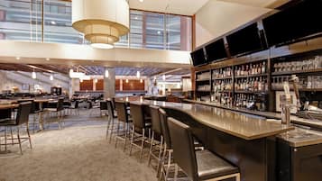 A spacious bar area with multiple seating options and a well-stocked liquor shelf.