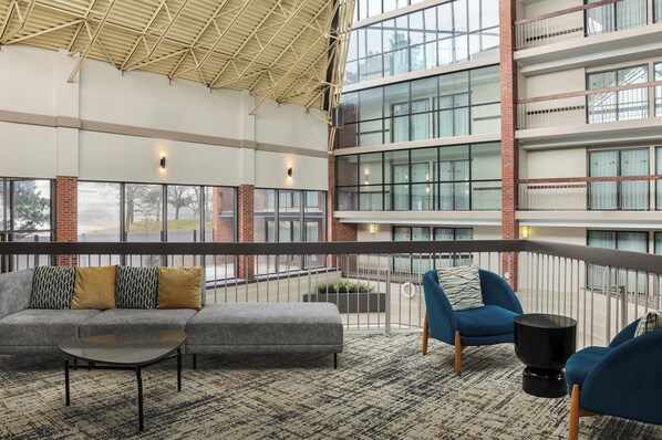 A spacious indoor area with a gray sectional sofa, blue armchairs, and a small black table.