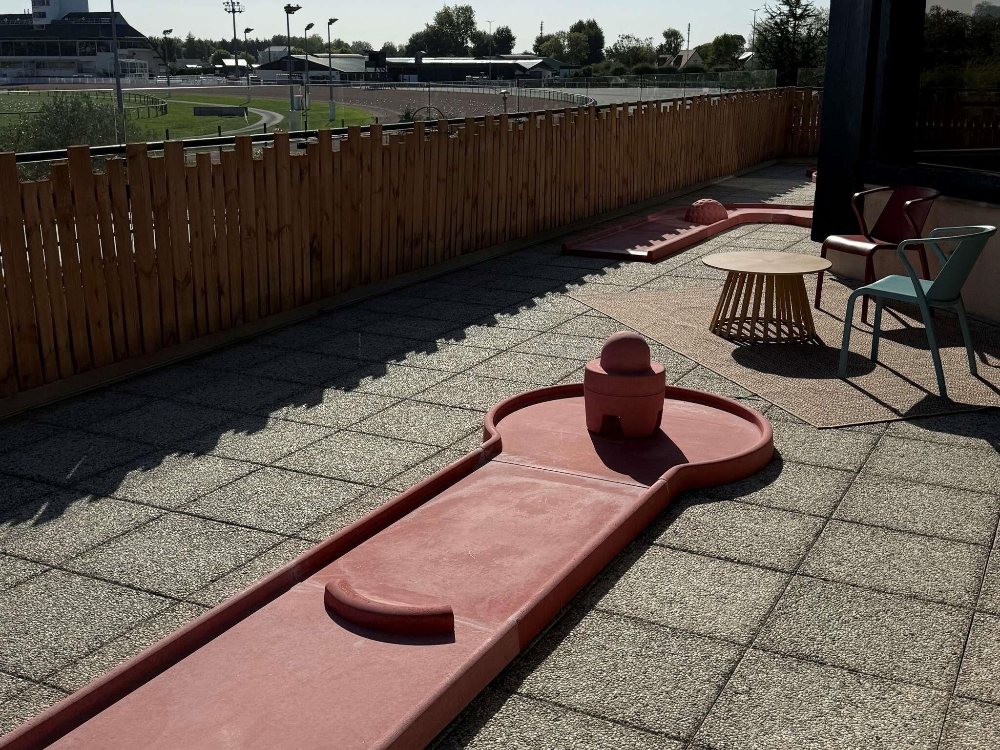 Une aire de jeux avec un toboggan et une petite table entourée de chaises.