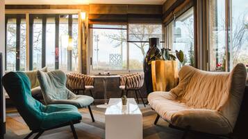 A modern living room with large windows, a coffee table, and two sofas.