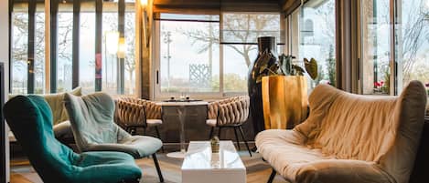 Una sala de estar moderna con ventanas amplias, una mesa de centro y dos sofás.