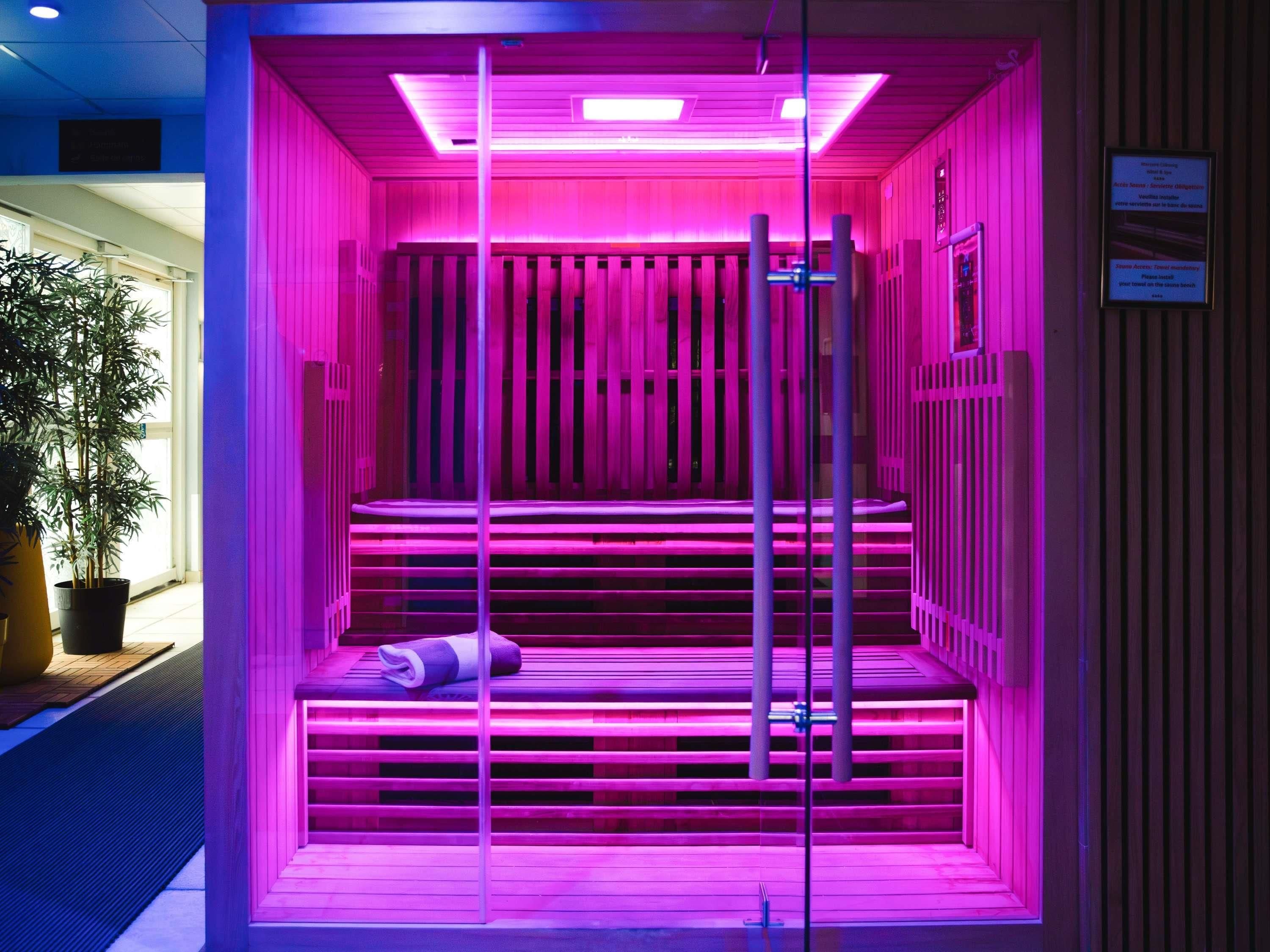 Ein Zimmer mit einer Wand aus Holzlatten, einer Bank mit Handtuch und einem Metallgeländer.