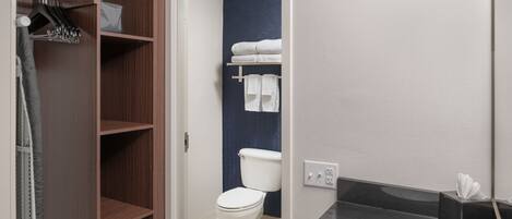 Un baño moderno con tocador de madera, lavabo blanco y pared decorada en azul.