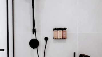A modern bathroom with a shower, a toilet, and a sink.