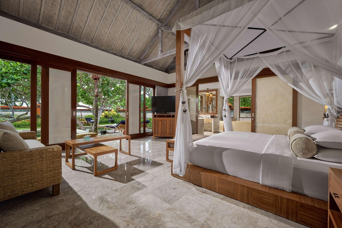 A spacious room with a large bed, a television, and a view of the outdoors.