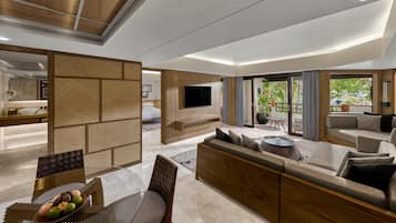 A modern living room with a sofa, TV, and a dining area with a table and chairs.