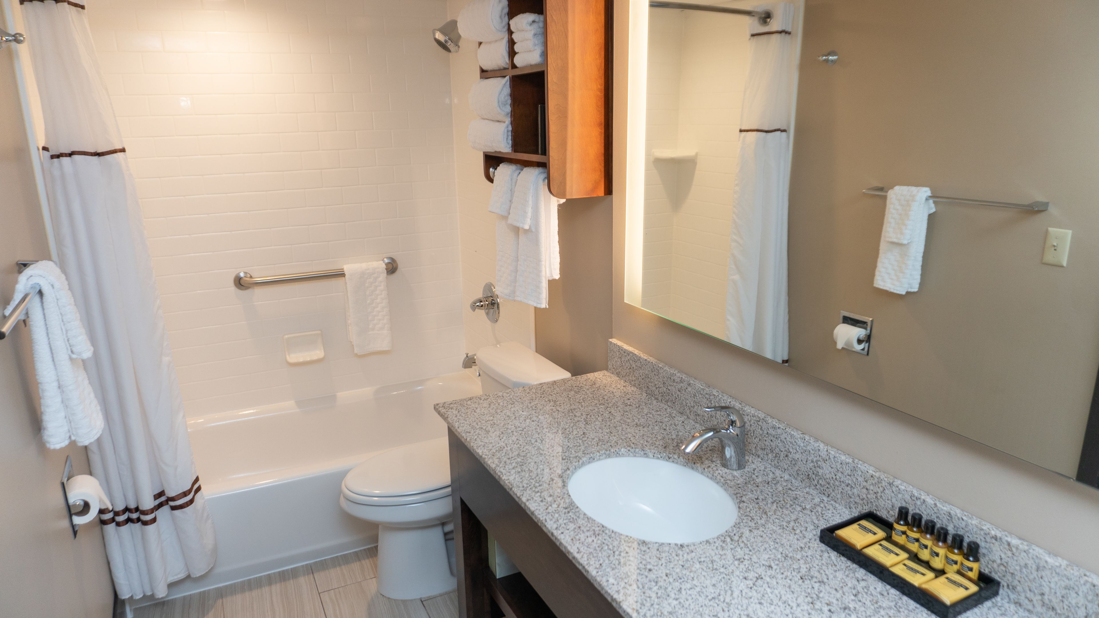 A bathroom with a bathtub, toilet, sink, and a mirror.