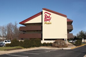 A Red Roof Plus hotel with a multi-story structure and a parking lot in front. - Red Roof Inn PLUS+ Philadelphia Airport (Essington)