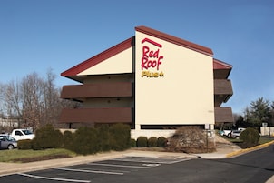 A Red Roof Plus hotel with a multi-story structure and a parking lot in front.