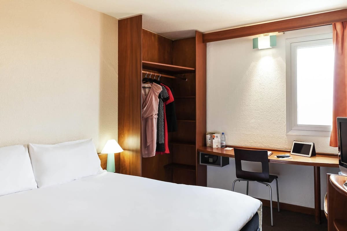 Ropa de cama de alta calidad y caja de seguridad en la habitación