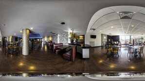 Un restaurante moderno con techo curvo, suelo de madera y una variedad de opciones de asientos, incluyendo cabinas y mesas.