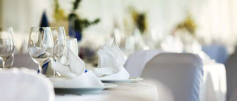 A table set for dining with white tablecloths and napkins.