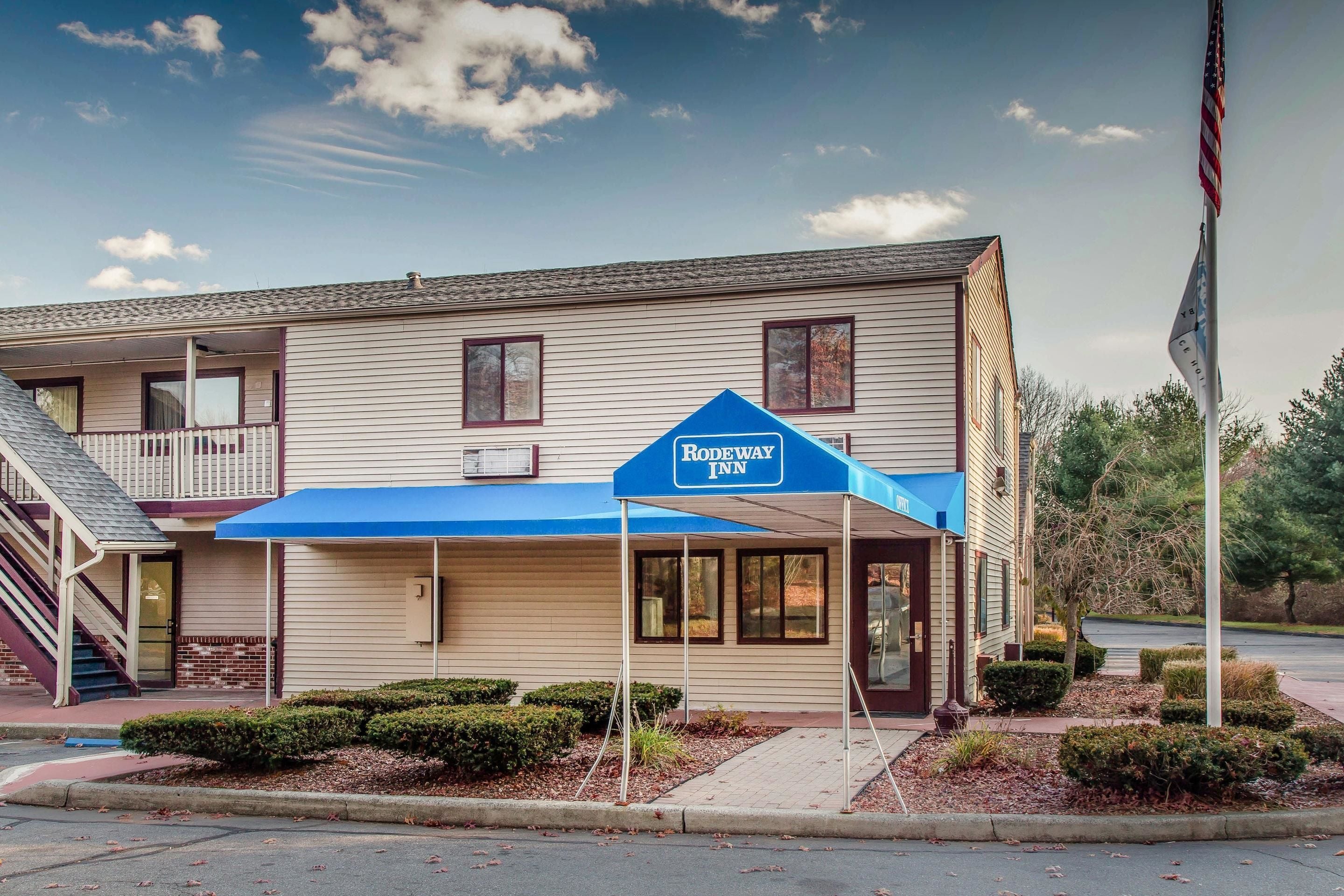 Un motel de dos pisos con toldo azul y un letrero que dice 'Rodeway Inn'.