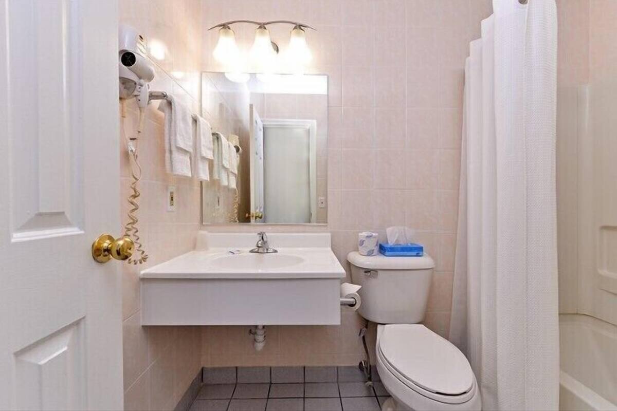 Un baño pequeño con un lavabo blanco, un inodoro y un espejo sobre el lavabo.