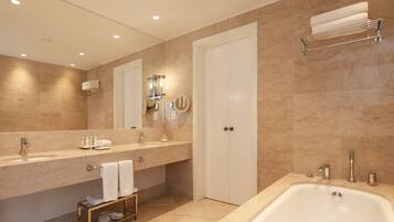 Un baño moderno con una bañera grande, un tocador con espejo y un perchero para toallas.